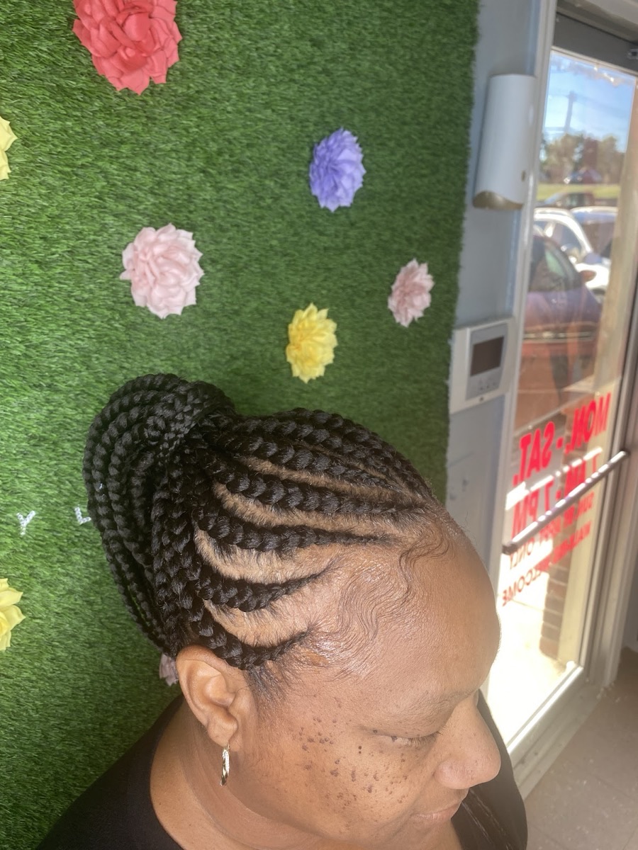 Neat feed-in cornrows gathered into a bun at 3JJJ Hair Braiding