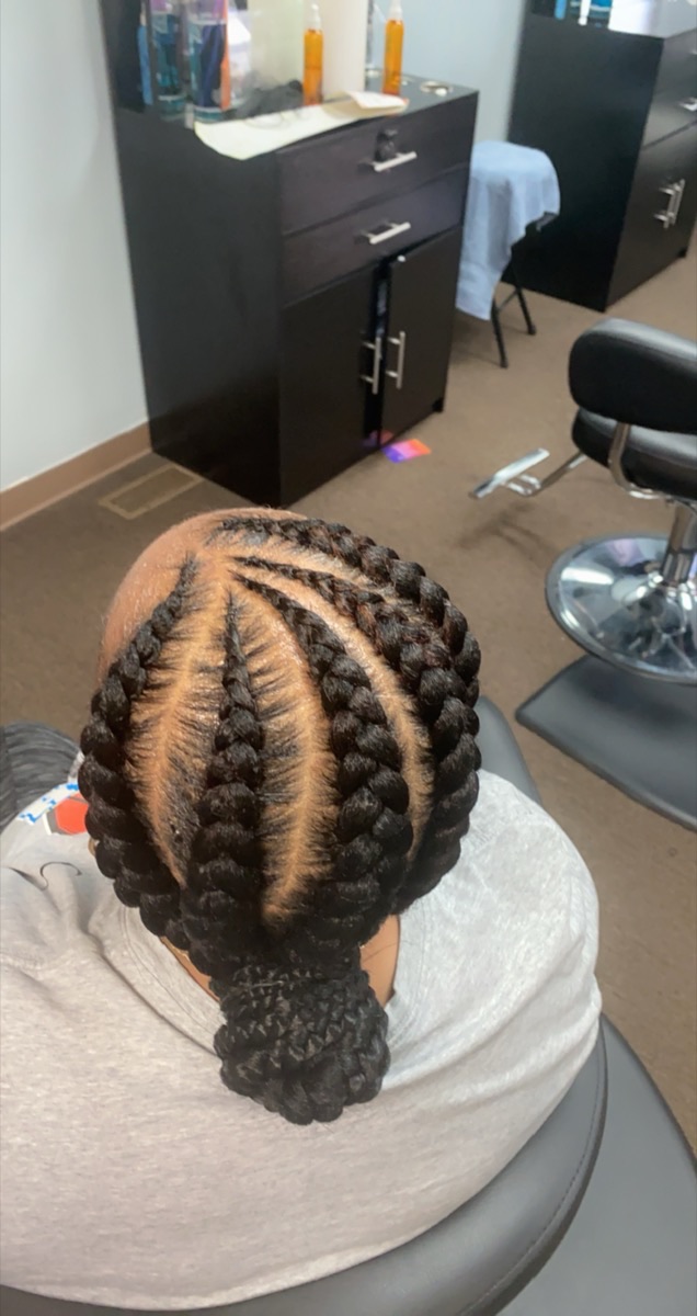 Crisp stitch cornrows styled into a low bun at 3JJJ Hair Braiding
